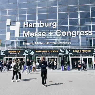 ATZ-Group-Marketingmitarbeiterin läuft auf Hamburg Messe + Congress Gebäude zu